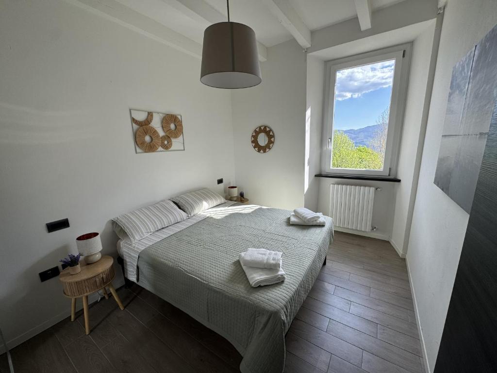 a white bedroom with a bed and a window at alloggioaltorrione in Citerna