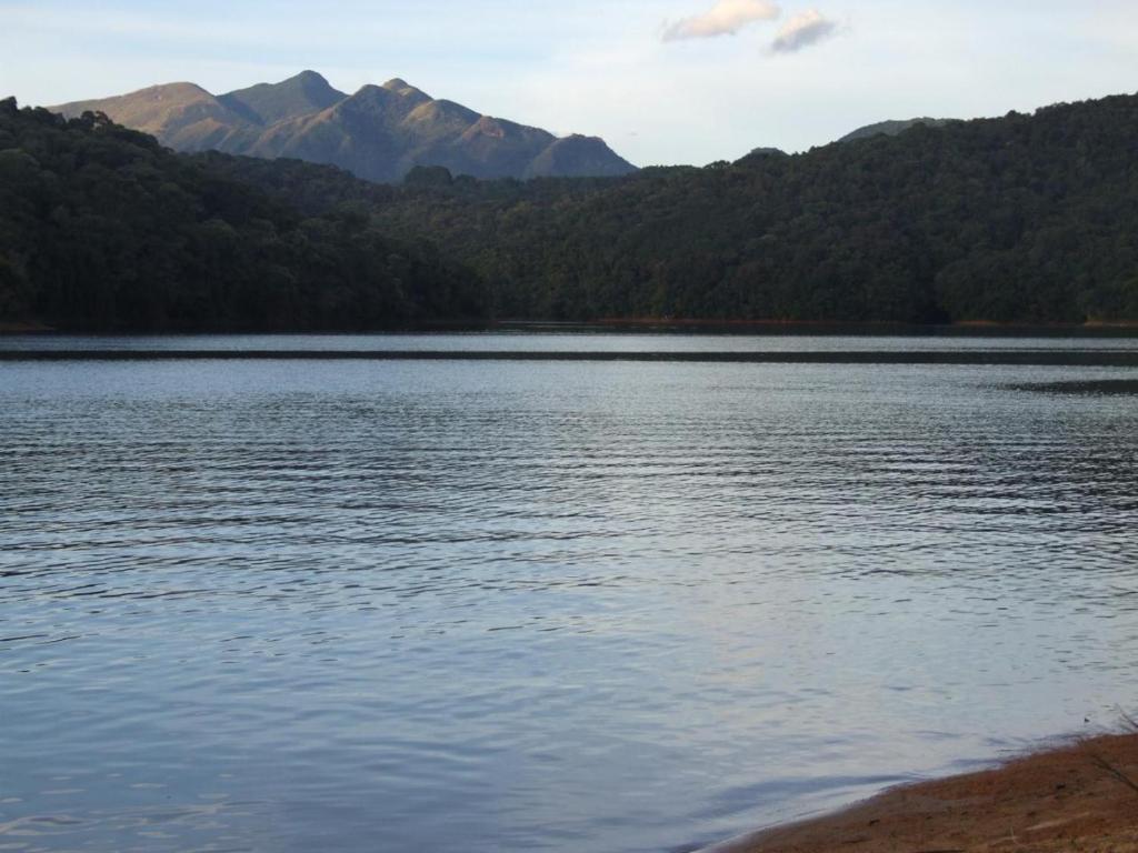 a large body of water with mountains in the background at Cabana Paiol de Baixo in Curitiba