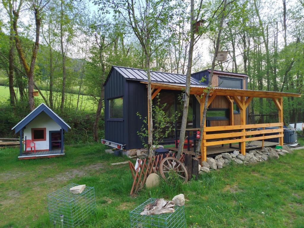 a black tiny house in the woods with a porch at Anciasglamp in Dolný Kubín
