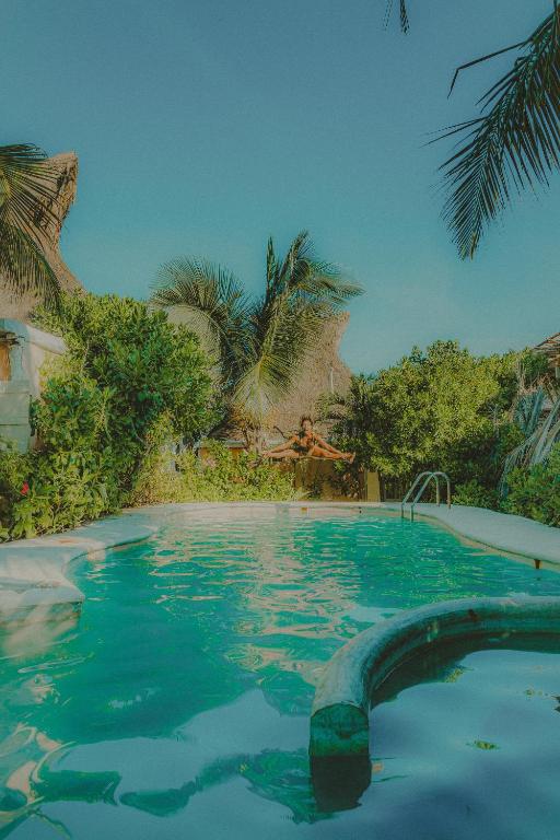 a large swimming pool with a person in the background at Villa Las Estrellas Tulum - located at the party zone in Tulum