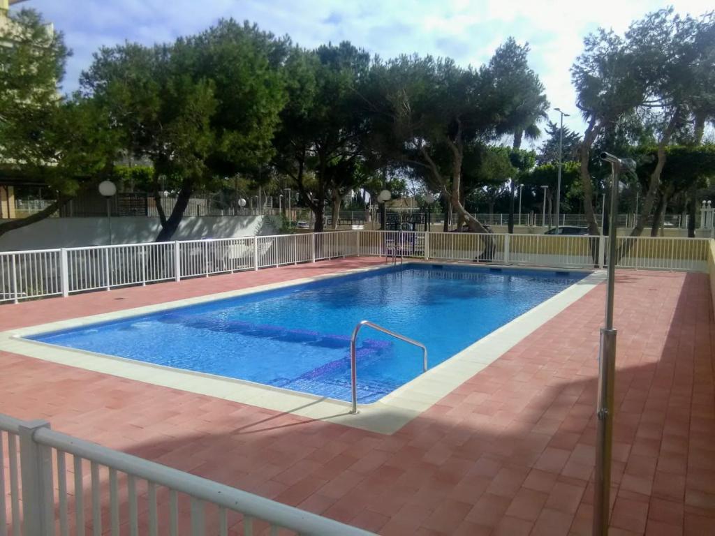 a large swimming pool with a fence around it at Malvarrosa, 1-6 in Cullera