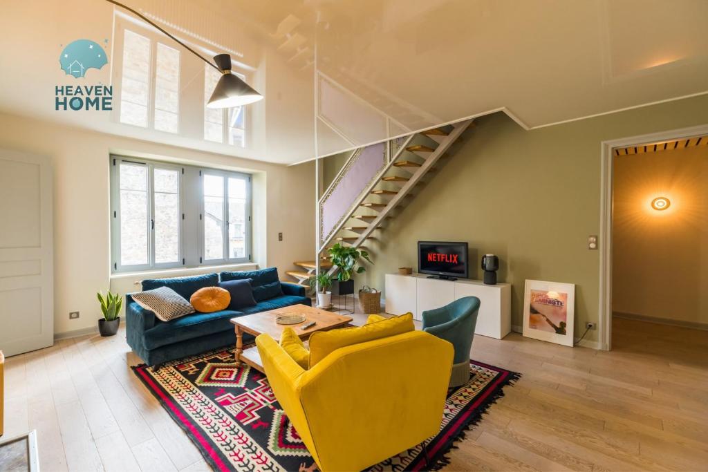 a living room with a blue couch and yellow chairs at Appartement d'exception - proche de la mer in Saint-Brieuc