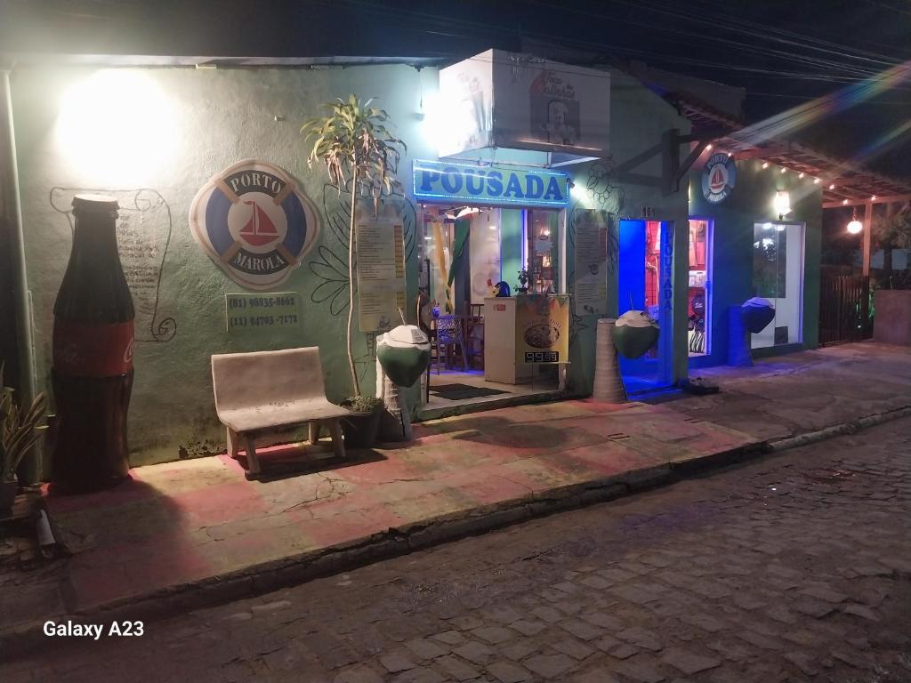 a street at night with a building and a bench at Pousada Porto Marola in Porto De Galinhas