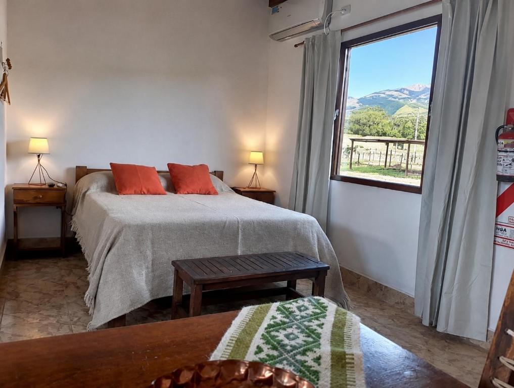 a bedroom with two beds and a large window at Entre Montañas in Tafí del Valle