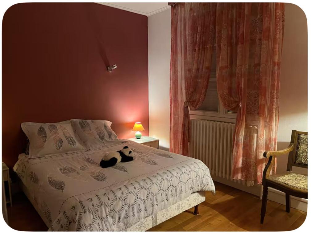 a bedroom with a black cat sitting on a bed at Chambre à deux pas de Beauval in Montrichard
