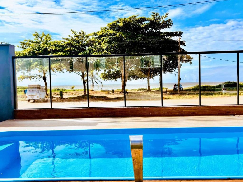 a swimming pool with a view of the ocean from a house at Pousada Sol & Mar Jacaraìpe ES in Serra