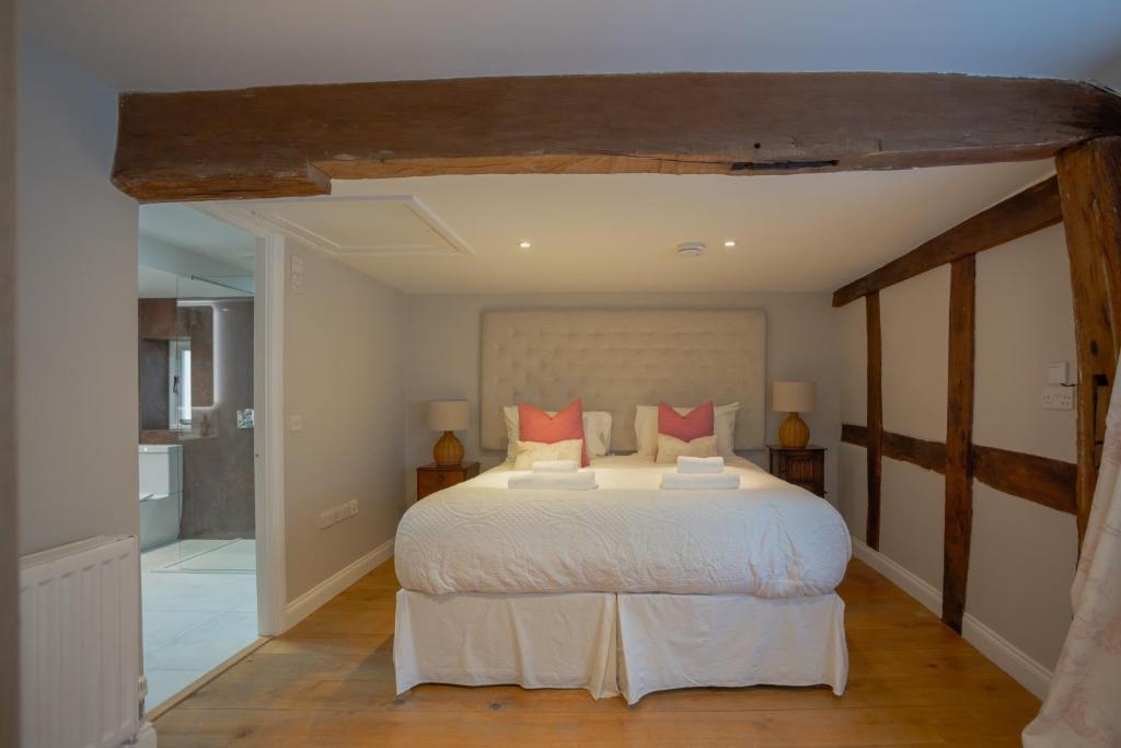 a bedroom with a large white bed with red pillows at Characterful Home Steps from Cathedral in Hereford
