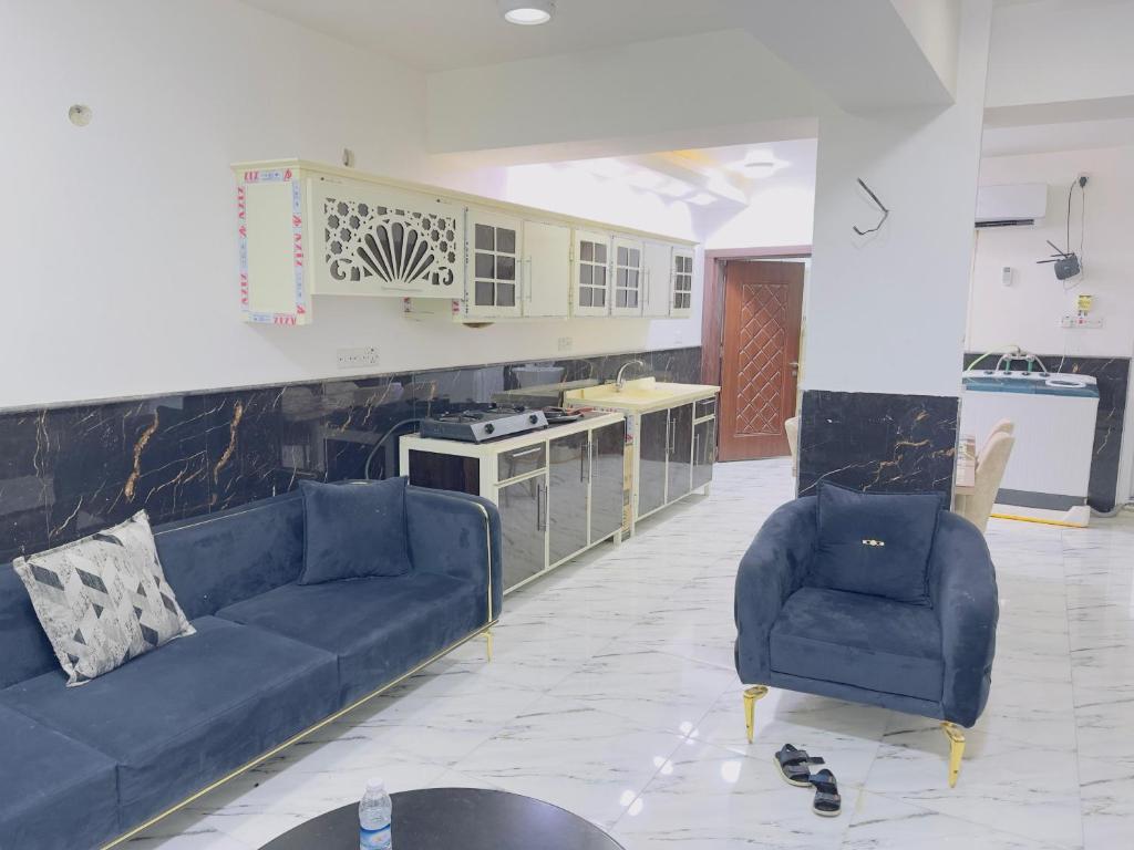 a living room with a blue couch and a kitchen at مضيف الزهراء in Karbala