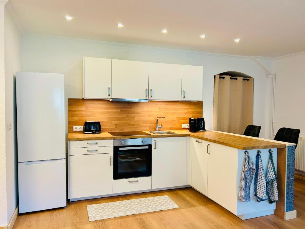a kitchen with white cabinets and a white refrigerator at Ferienwohnung Alpenpfad in Elmen