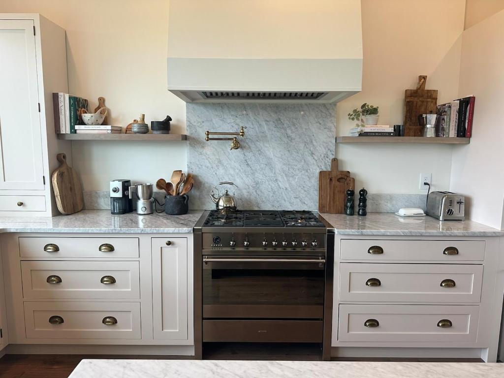 a kitchen with a stove and white cabinets at The Llama Lane House in Yakima