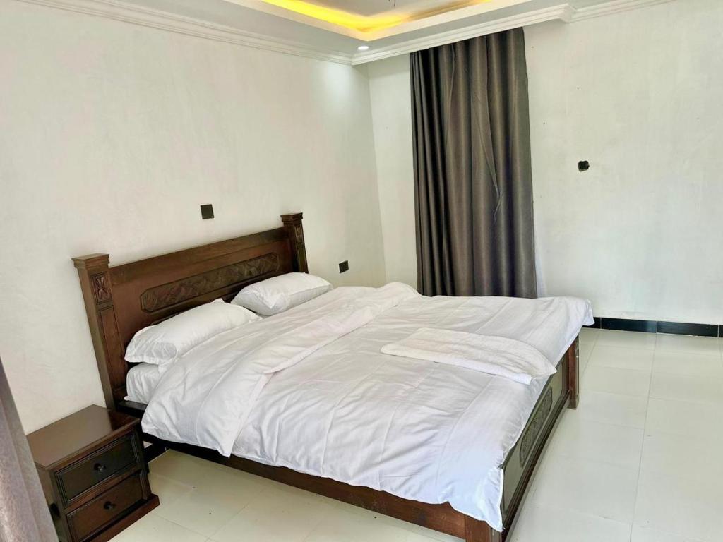 a bedroom with a large bed with white sheets at Kithumulani Resort in Tiva
