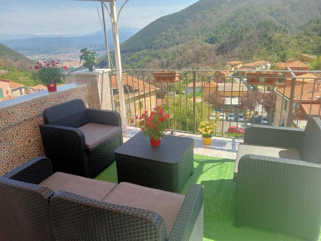 a balcony with chairs and tables and a view of a mountain at zahira in Biassa