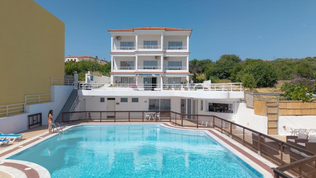 a building with a swimming pool in front of a building at CHIOS HOTEL in Katarráktis
