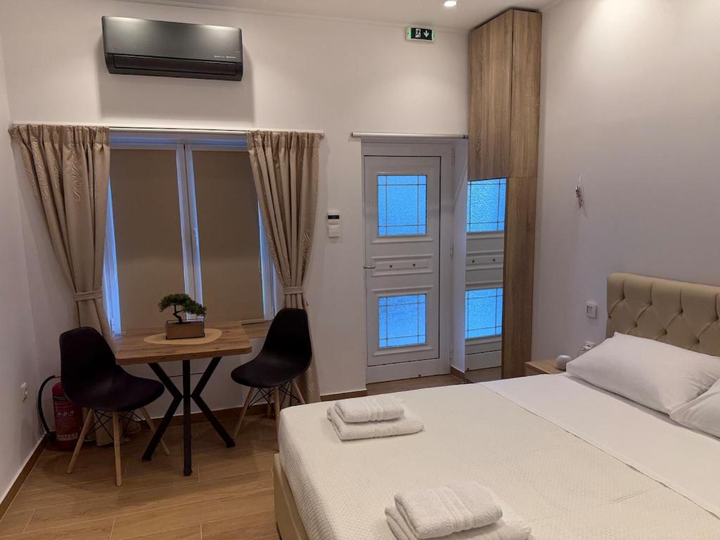 a bedroom with a bed and a table and chairs at Prime 27 Luxury Studio in Lavrio