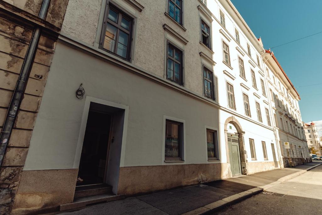 a large white building with a doorway on a street at City Center Studio in Graz