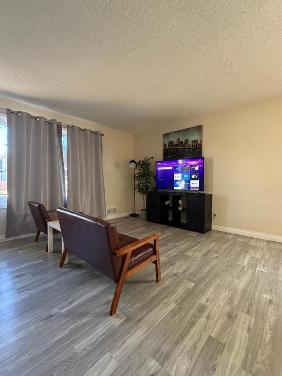 a living room with a couch and a tv at UofC-SAIT-Banff Trail-Suite A&B in Calgary