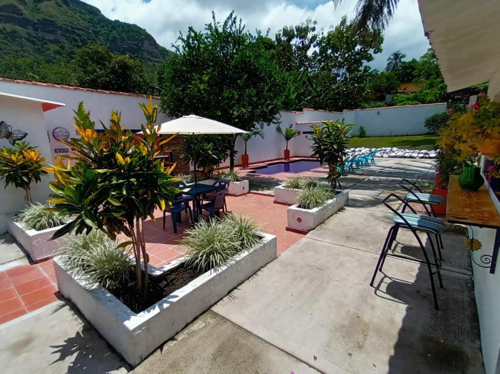 a patio with tables and chairs and a pool at Casa Rotario Honda in Honda