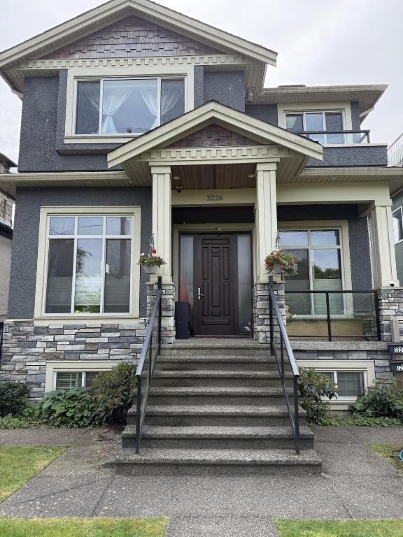 a house with a black door and stairs at Garden suite in Vancouver