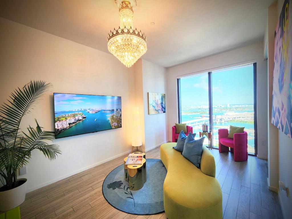 a living room with a yellow couch and a large window at Marina Miami Penthouse- Downtown-Brickell 2BD-2BA in Miami