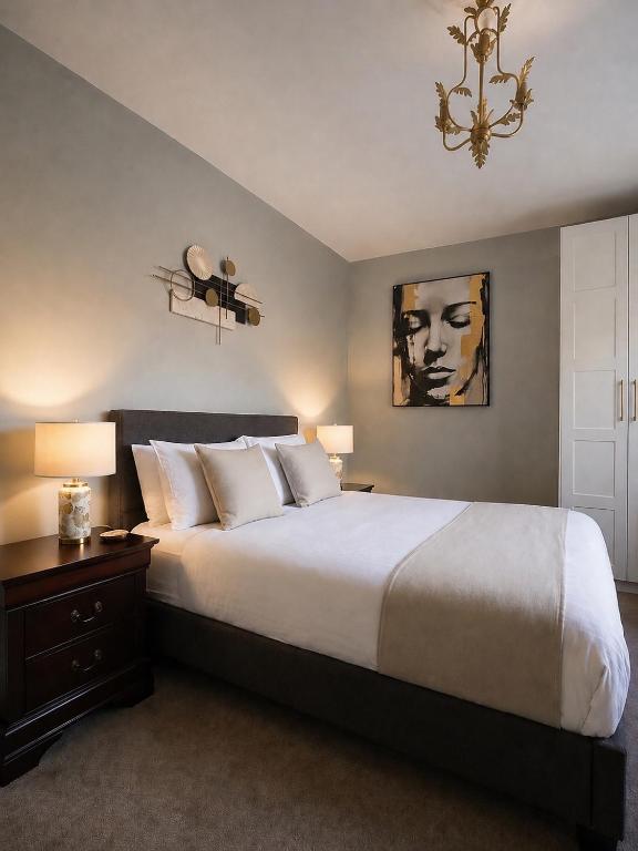 a bedroom with a large white bed and a chandelier at The Hillcrest, Luxury Accommodation in Castleblayney Town in Castleblayney