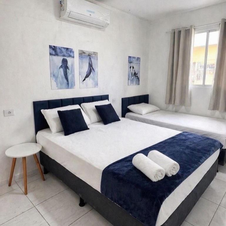 two beds in a bedroom with blue and white at Casa no centro de Ponta de Pedras - Casa da Baleia VILA ORION in Goiana