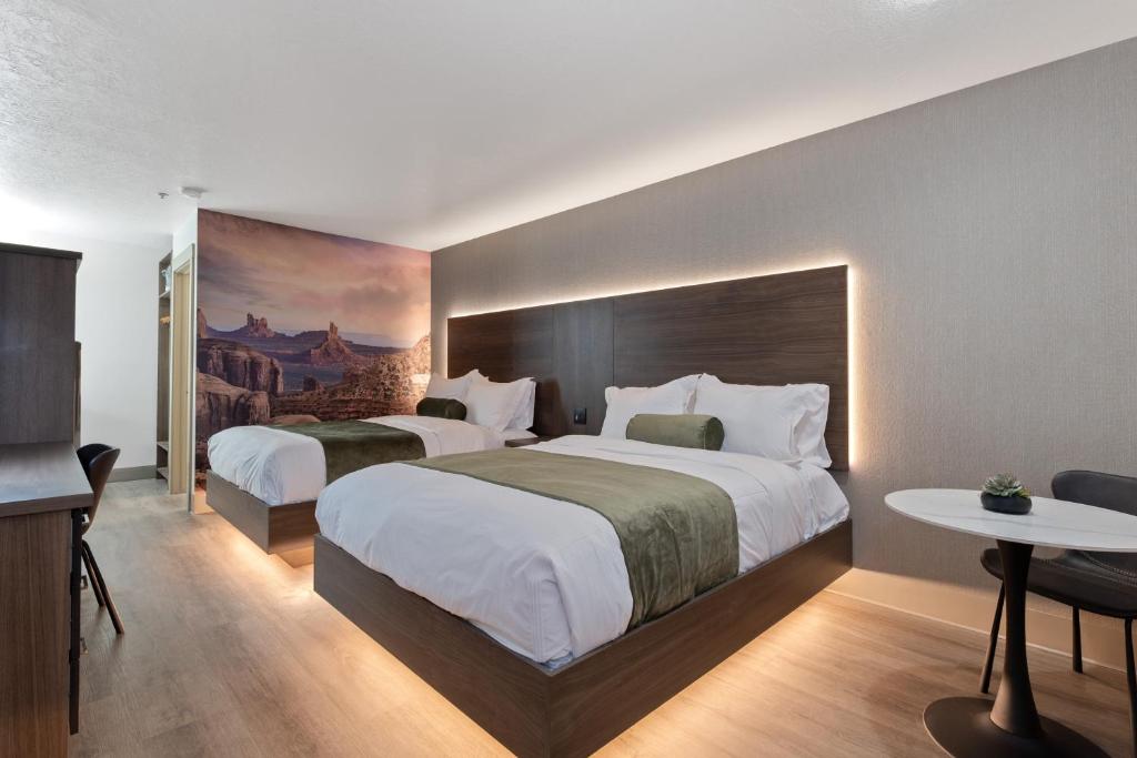 a hotel room with two beds and a painting on the wall at Zion Promenade Hotel in St. George