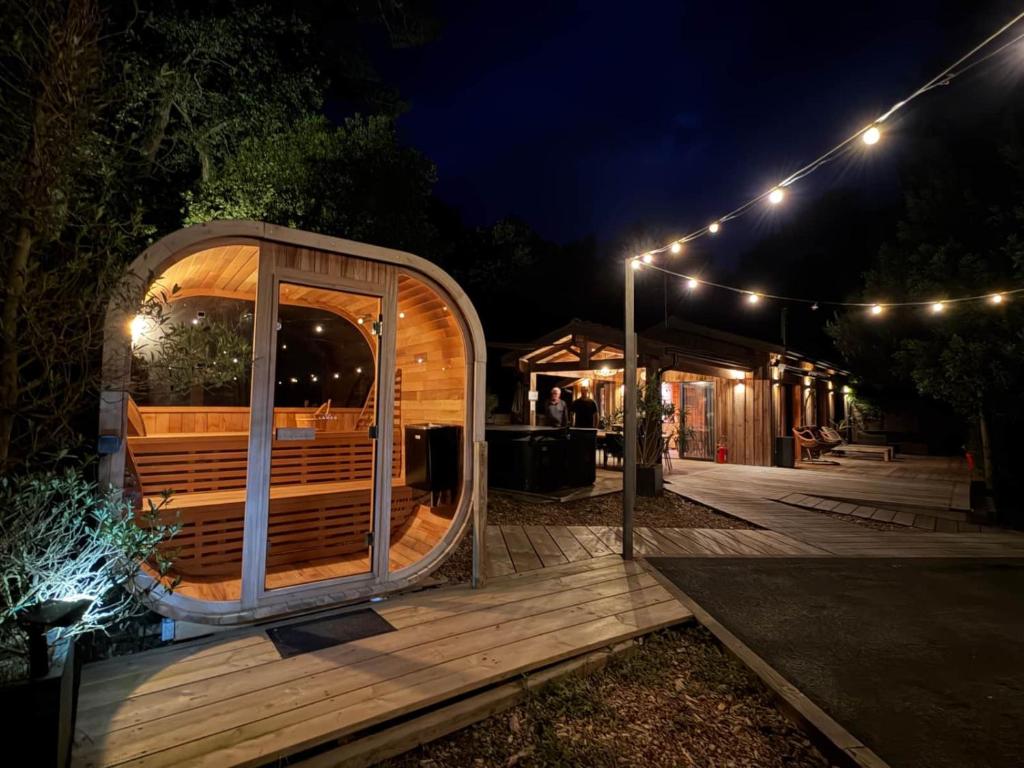 a wooden deck with a sauna at night at Le Chalet Maguide in Biscarrosse