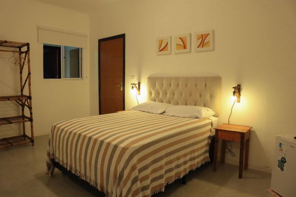 a bedroom with a bed with a black and white striped blanket at Hotel Pousada Ibituruna inn in São Paulo
