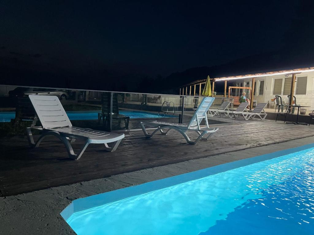 a couple of chairs sitting next to a swimming pool at night at CHRIS SOPO in Ohrid
