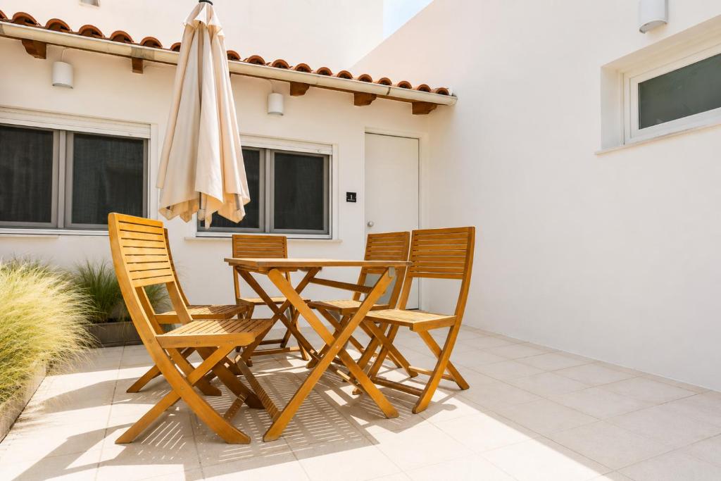 a table and chairs and an umbrella on a patio at Dorothy's Apartments Near Athens Airport By SEM in Artemida