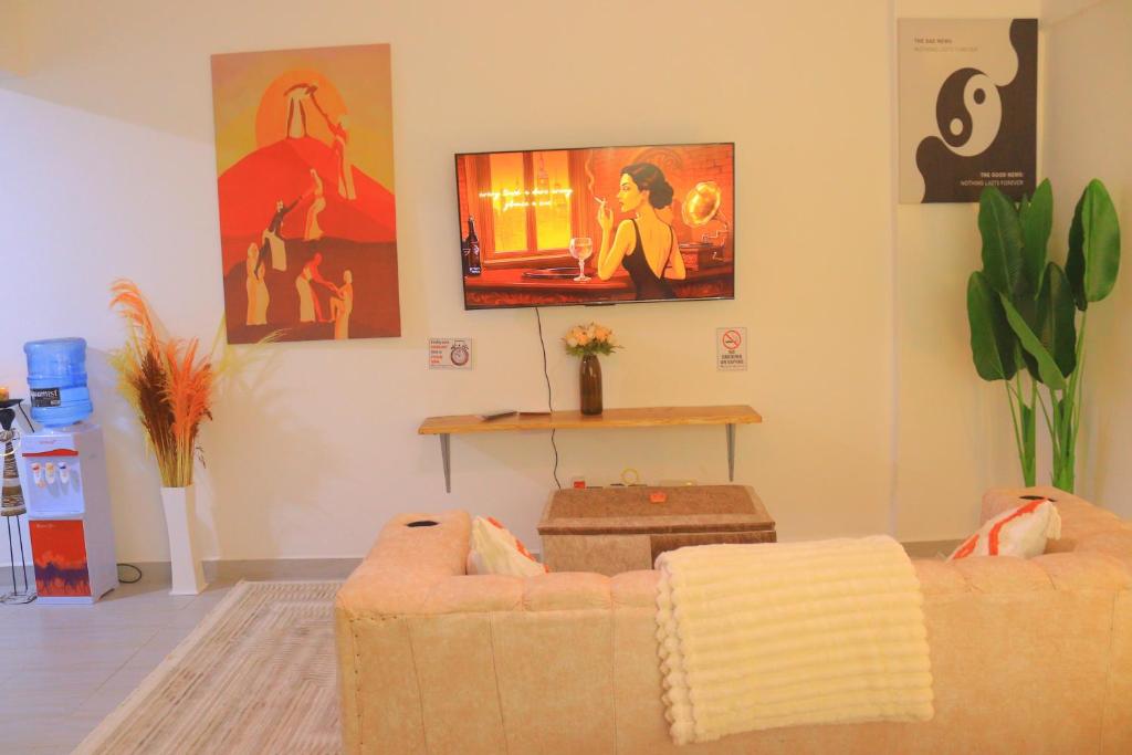 a living room with a couch and a tv on the wall at Polea Hapa Ruaka in Nairobi