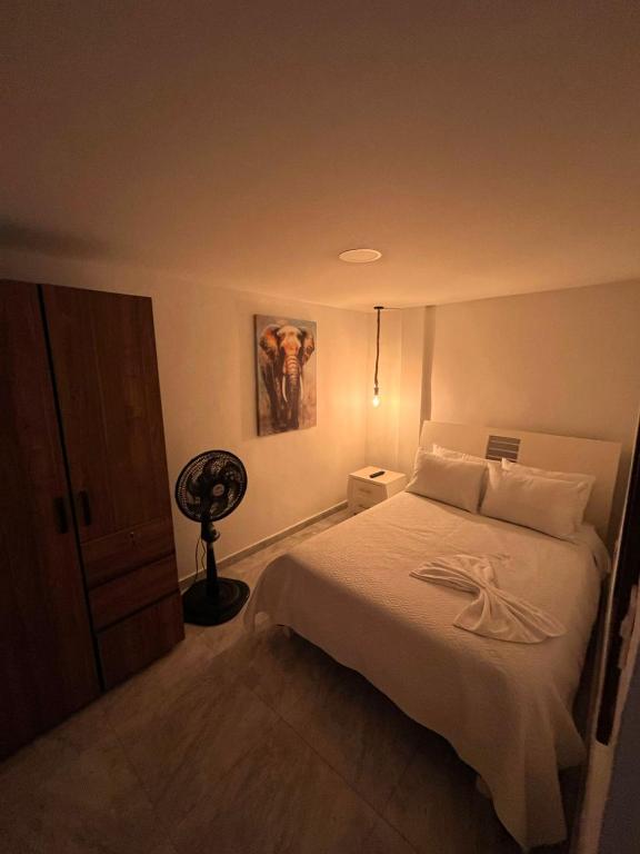 a bedroom with a bed and a fan on it at Apartamento amoblado Chinchina in Chinchiná