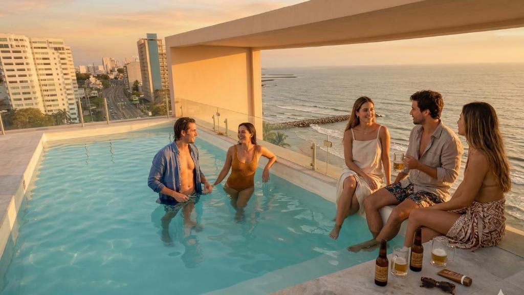 a group of people sitting in a swimming pool at Grandeza by Palms Boca del Río in Boca del Río