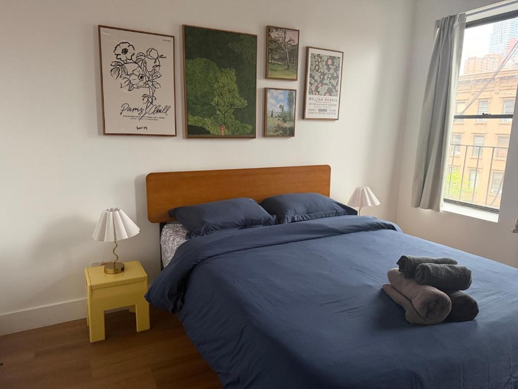 a bedroom with a blue bed with a stuffed animal on it at The Revival Guest House near Times Square in New York