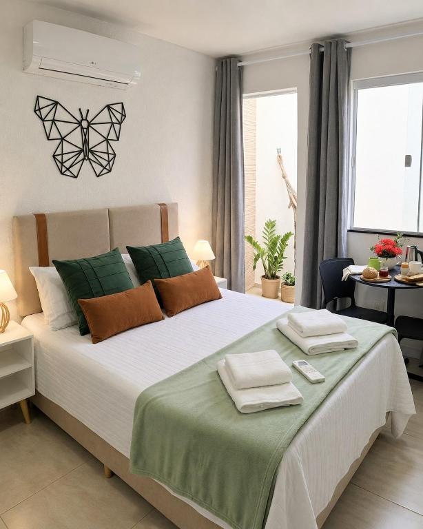 a bedroom with a large bed with towels on it at Aconchego das Borboletas in Salvador