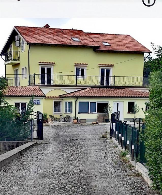 a large yellow house with a road in front of it at Apartman Emily in Čavle