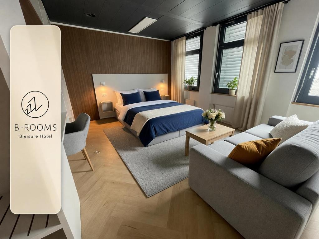 a bedroom with a bed and a couch at B-ROOMS Bleisure Hotel - Lugano district in Manno