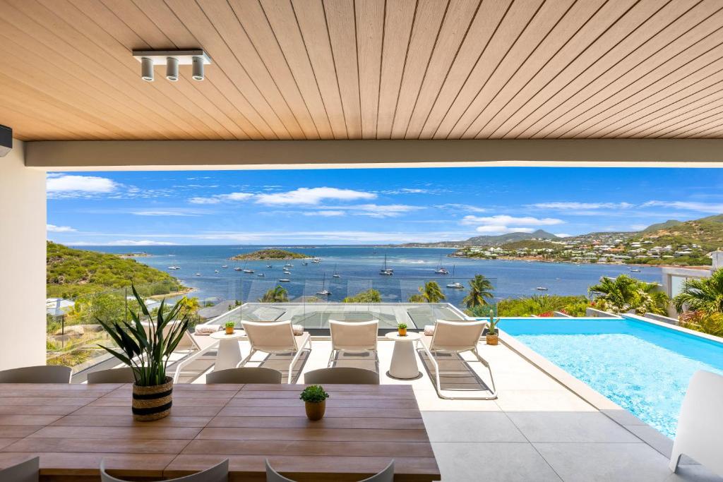 a view of the ocean from a house with a swimming pool at Résidence AMARILLO Vue mer exceptionnelle face à Saint-Barthélémy in Cul de Sac