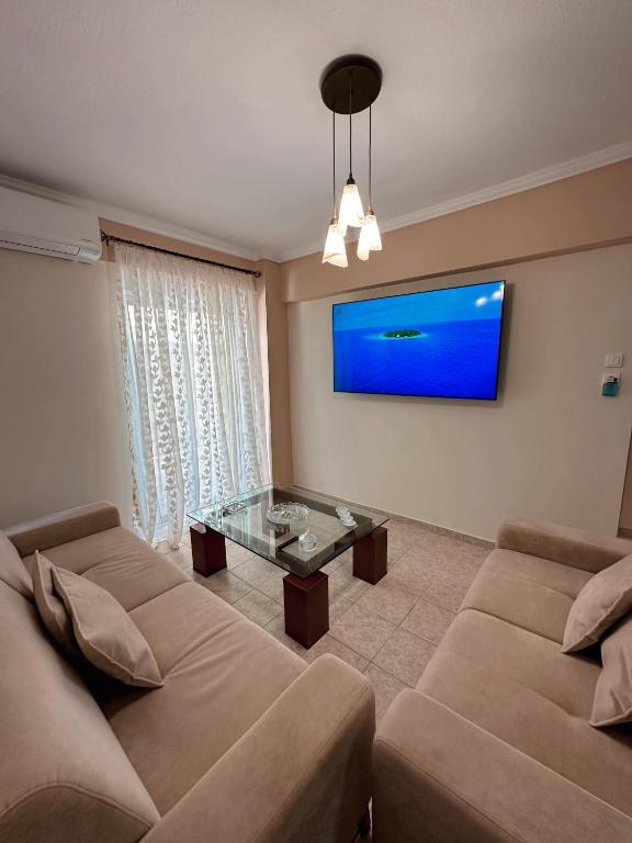 a living room with two couches and a tv at DIARA APARTMENT in Nea Irakleia
