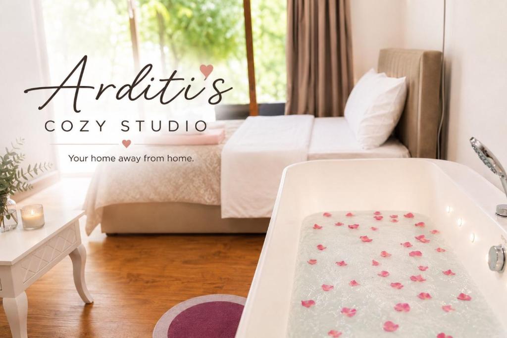 a room with a bed and a bath tub with pink flowers at Arditis Cozy Studio in Bogë