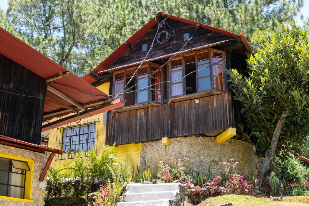 a yellow house with a red roof at Hotel Posada La Ermita Cobán in Cobán