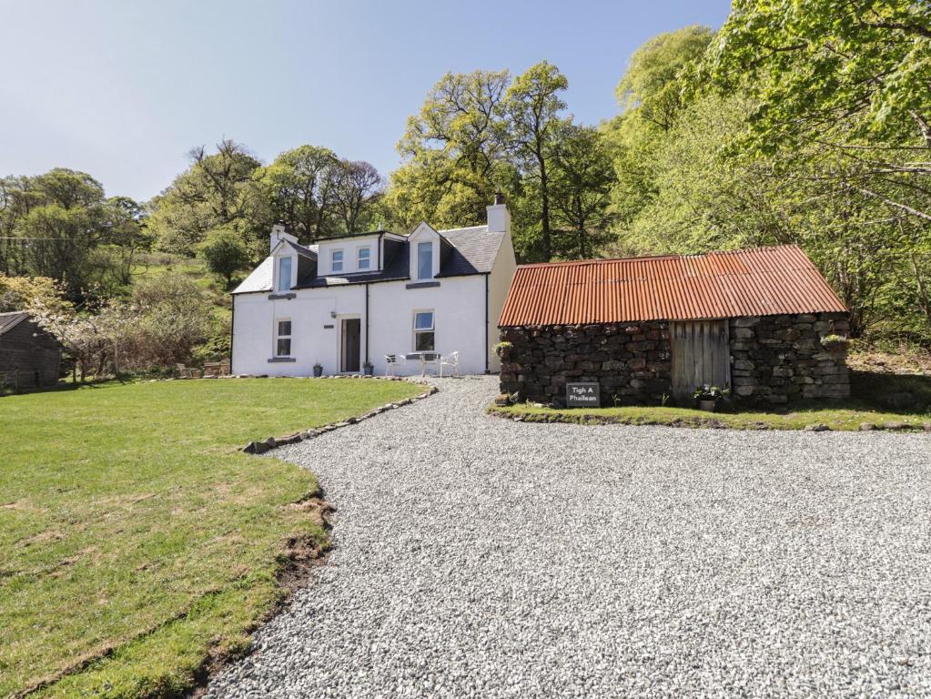 a white house with a barn and a gravel driveway at Tigh a Phailean in Letterfearn