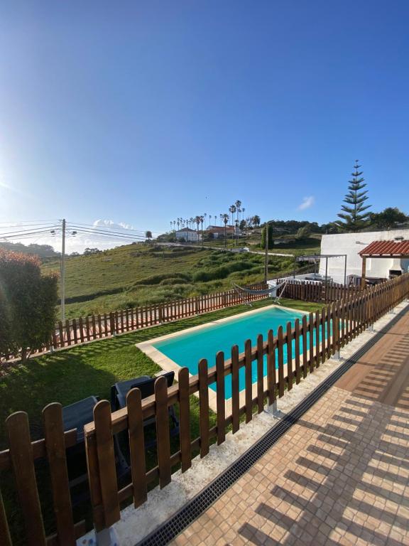 a swimming pool next to a wooden fence at Like a Local Guest House in Ericeira