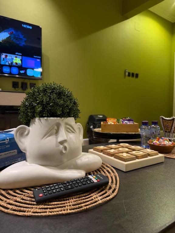a statue of a head with a potted plant on a table at شقة مروج هاوس دخول ذاتي in Hail