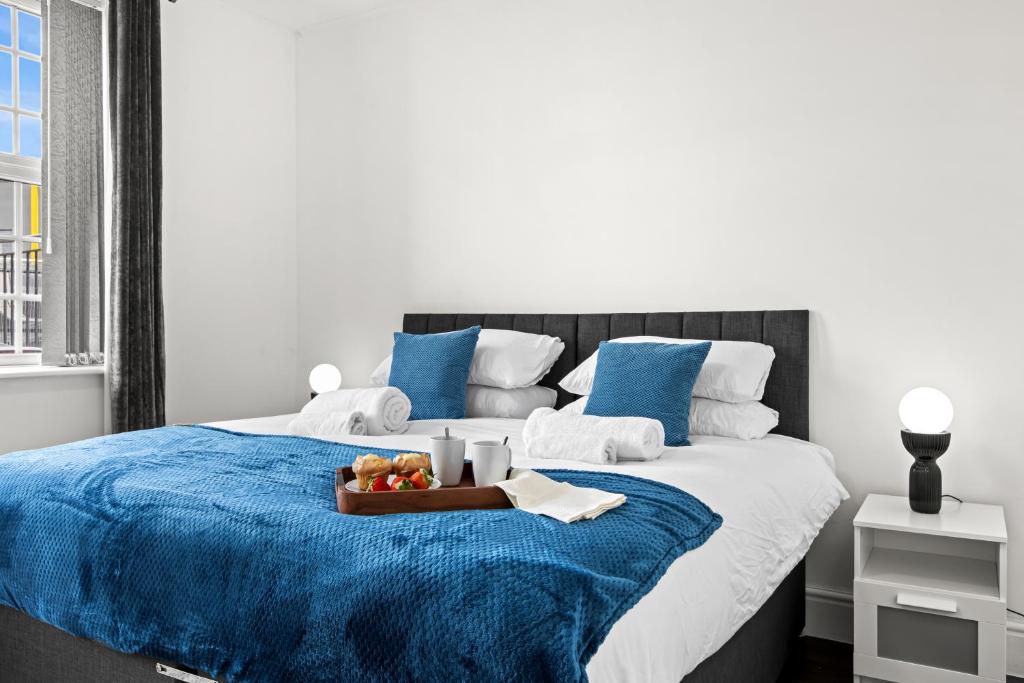 a bed with a tray of fruit on a blue blanket at Cheshire Dimond one bedroom flat in Warrington in Warrington