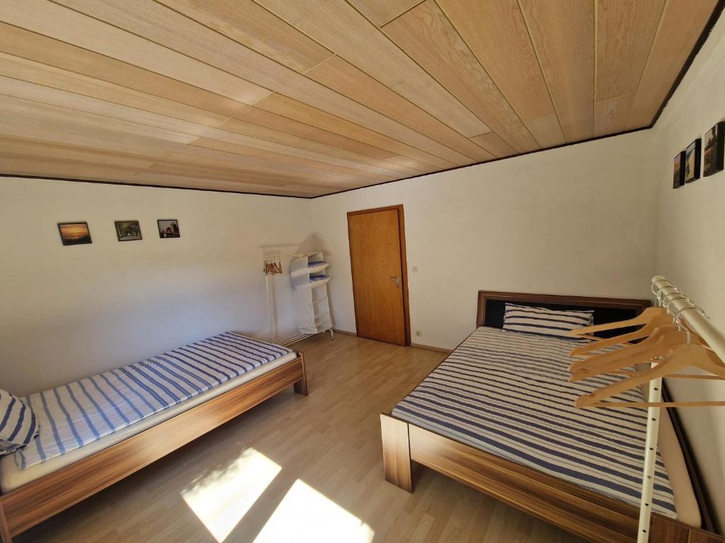 two beds in a room with a wooden ceiling at Monteurenwohnung Chez Danou in Idar-Oberstein