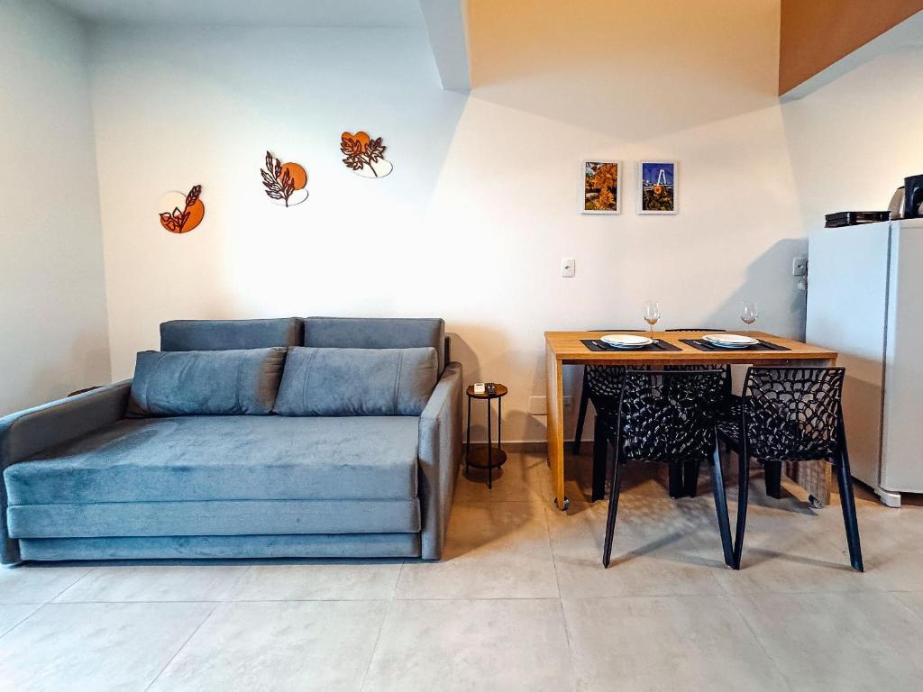 a living room with a couch and a table at Loft Novo e Completo no Centro • 4 Pessoas in Brusque