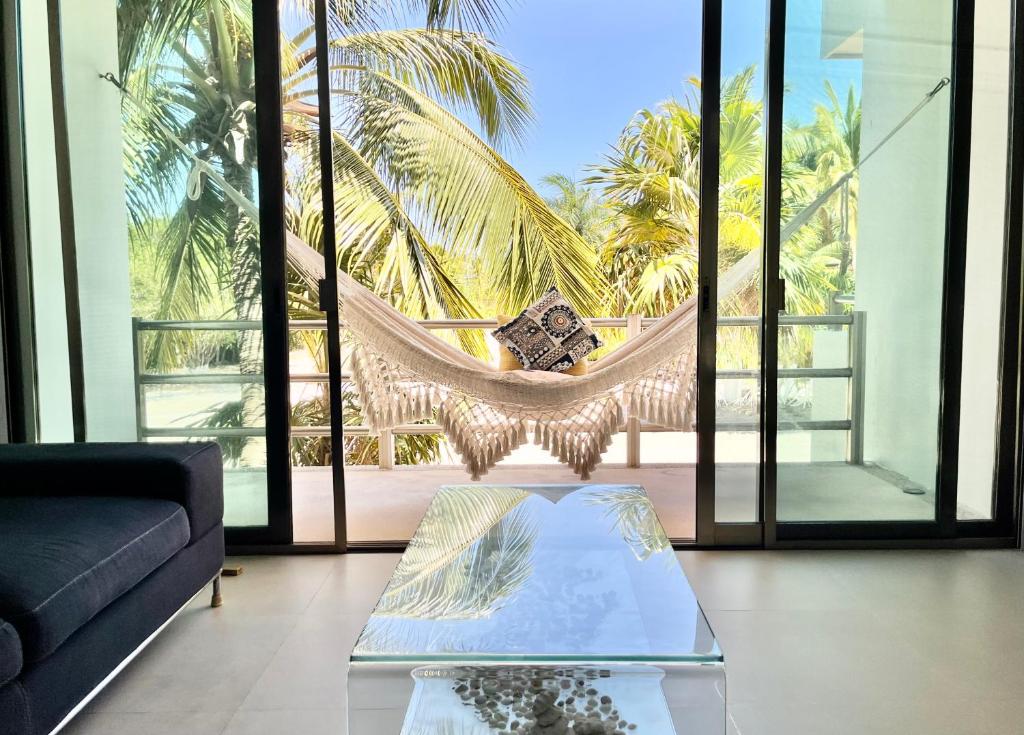 a living room with a hammock and palm trees at Escape to a peaceful side of the Riviera Maya in Lafitte