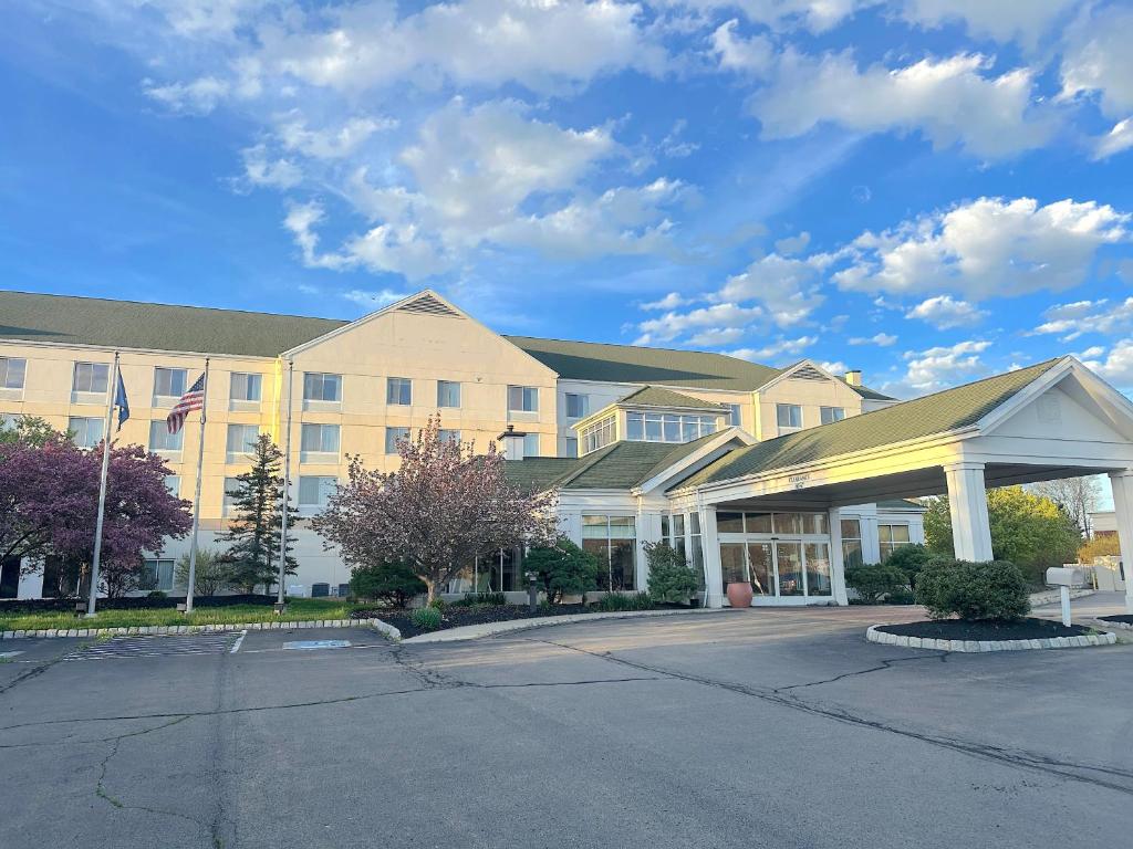 a hotel with a parking lot in front of it at Arnot Grand Hotel & Suites in Horseheads