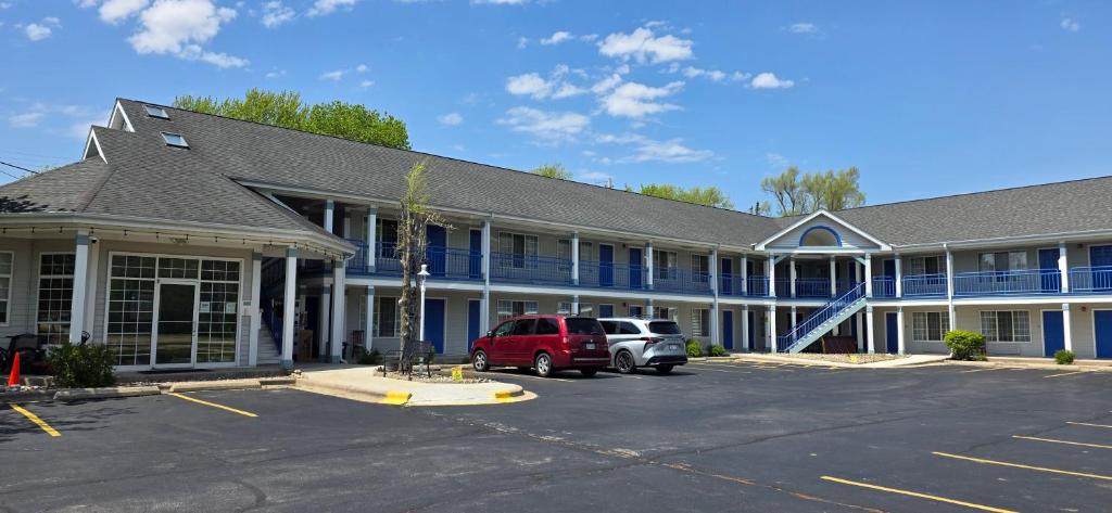 a building with a red van parked in a parking lot at Fontana Village Inn in Lake Geneva